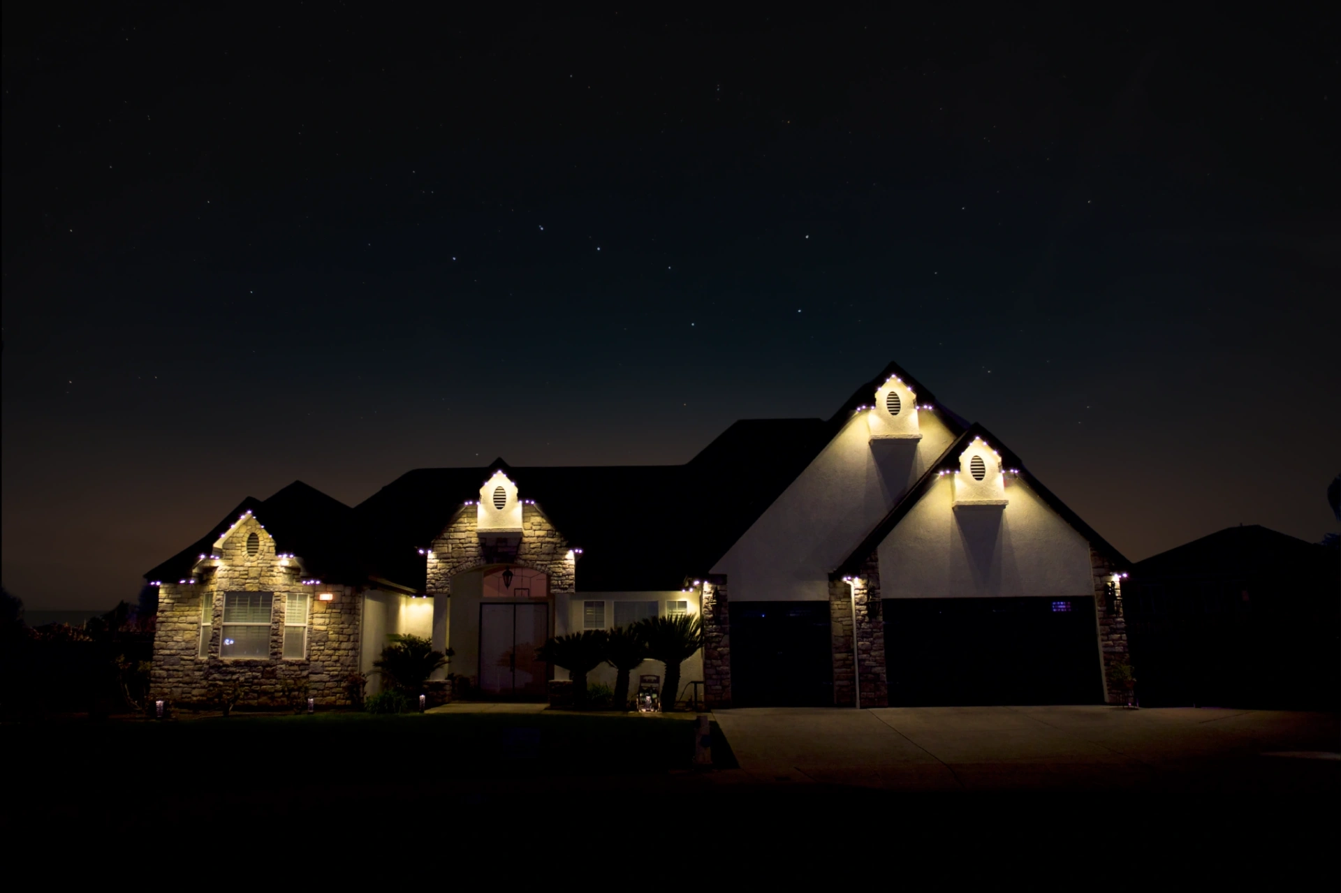 Home at night with individually controlled warm white bluEmber lights along every roofline and peak