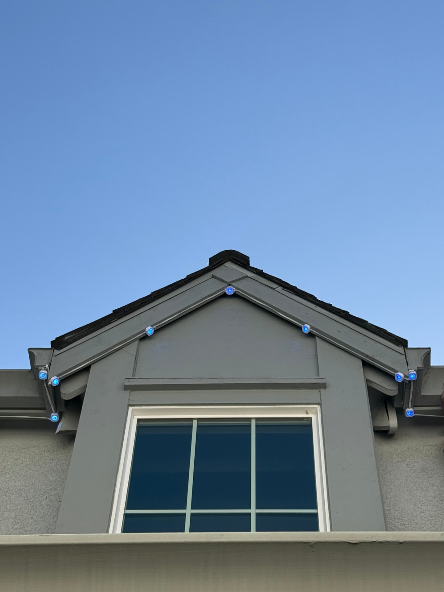 Govee LED puck lights mounted under a fascia board glowing pink and purple