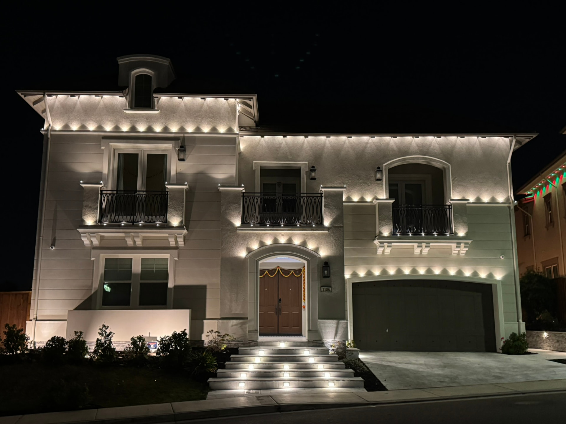 Two story Danville home outlined with warm white permanent LED roofline lighting at night